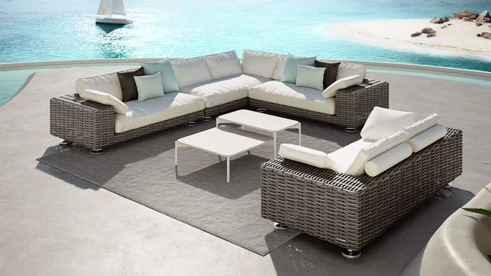 Dedon Paros modular outdoor sofa in Silt fiber on stainless steel feet in a garden